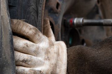 Changing a wheel. Close-up of loosening and tightening wheel bolts. Seasonal tire change. Part of...
