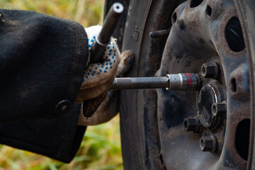 Changing a wheel. Close-up of loosening and tightening wheel bolts. Seasonal tire change. Part of the photo is blurred. The process of changing a car wheel. Close-up.