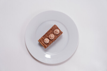 Isolated tiramisu cake on plate on white background, top view