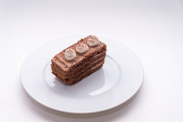 Isolated tiramisu cake on plate on white background, side view
