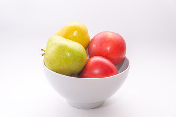 A bowl with pears and apples on a white background, side view