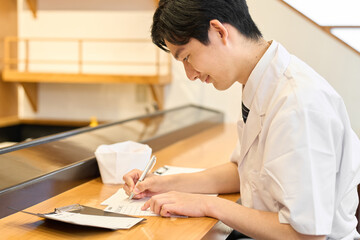 集計作業をする和食の料理人