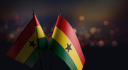 Small flags of the Ghana on an abstract blurry background