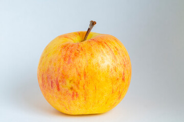 Ripe organic yellow apple on a white background