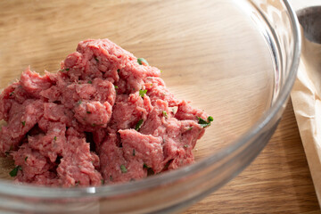 A closeup view of a glass bowl of ground beef.