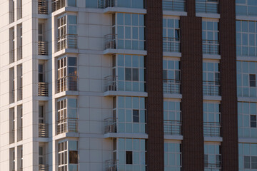Multi-storey buildings made of glass and concrete close-up. Toned