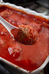 A view of a spoon scooping up a rice meatball.