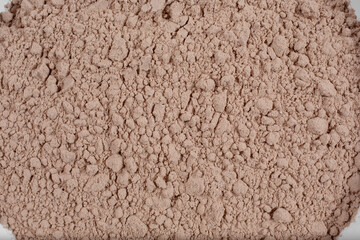 A top down view of a bowl of chocolate protein powder.