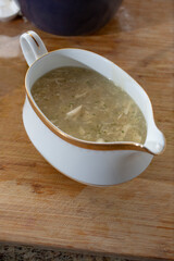 A view of a gravy boat filled with chicken gravy.