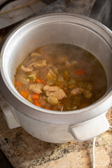 A view of chicken soup cooking in a rice cooker.