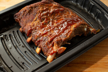 A view of a container of BBQ pork ribs.