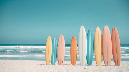 A collection of colorful surfboards stands in a neat row on a sandy beach, ready for an exciting day on the waves. The clear blue sky and bright sunshine set the perfect scene for a spring break