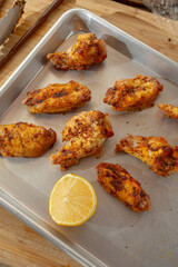 A top down view of several dry rub chicken wings on a baking sheet.