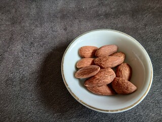 Bowl of Almonds on Textured Surface
