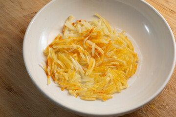 A view of a bowl of shredded hash browns.