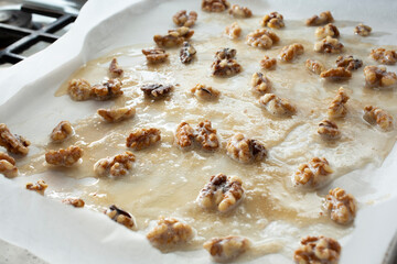 A view of candied walnuts drying on a baking sheet.