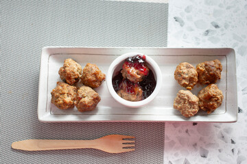 A top down view of an appetizer plate of grape jelly meatballs.