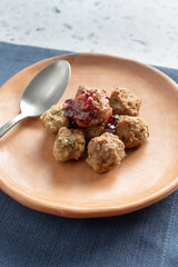 A view of a pile of grape jelly meatballs on a plate.