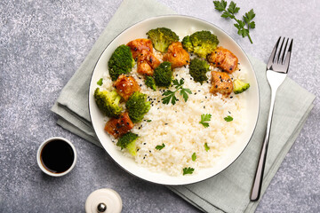 Tasty rice with broccoli and chicken served on grey table, top view