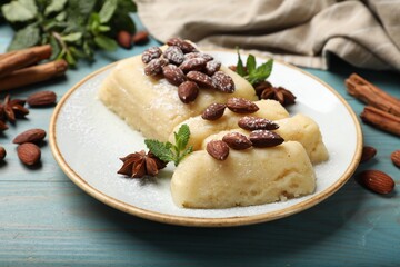 Delicious sweet semolina halva with almonds, spices and mint on light blue wooden table, closeup