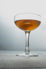 A view of an orange peel garnish inside a coupe glass cocktail.