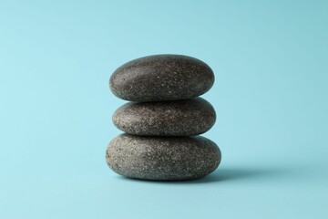 Stack of rocks on light blue background. Harmony and life balance