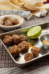 A view of a tray of teriyaki meatballs.