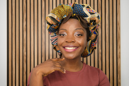 Smiling young black woman wearing a traditional African headscarf