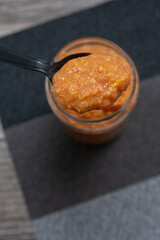 A view of a spoon in a glass of guava puree.