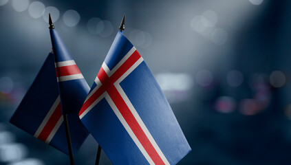 Small flags of the Iceland on an abstract blurry background