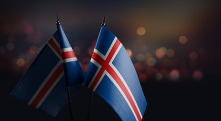 Small flags of the Iceland on an abstract blurry background