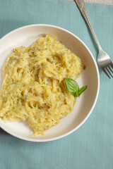 A top down view of a plate of spaghetti squash Alfredo.