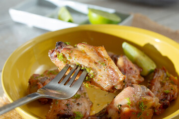 A view of a fork picking up a  tequila lime chicken wing.