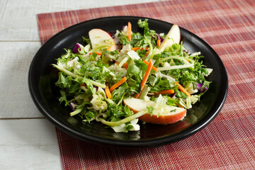 A view of a chopped salad, featuring apple slices.