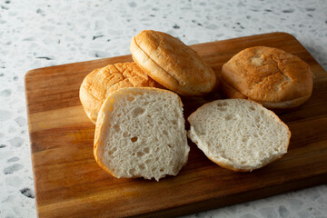 A view of several gluten-free burger buns, featuring one that is halved.