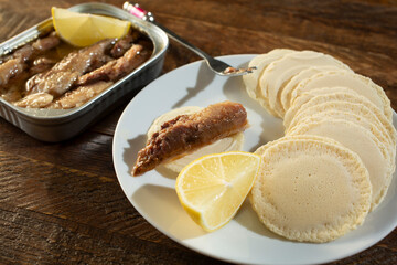 A view of an appetizer of canned sardines and crackers.
