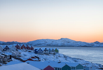 Nuuk the capital of Greenland.  Beautiful colored houses in a winter landscape by the sea at sunset. © Sarah Østergaard