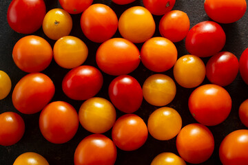 A top down view of a layer of teeny tiny tomatoes, as a background.