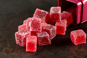A view of a pile of edible red sour candy spilling out of the package.