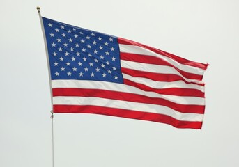 American flag waving in the wind with thirteen red and white stripes, blue field with fifty white stars, vibrant and dynamic appearance, shiny fabric