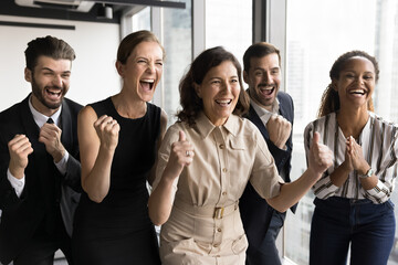 Obraz premium Group of diverse businesspeople celebrate moment of triumph and accomplishment, relish achievement, successful completion of project, reached milestone in business efforts, feel motivated, look joyful