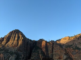 Sunrise Over Zion Canyon with Golden Light Flowing Through the Canyon Walls, Various Greenery of Early Spring May Landscape, and River Below