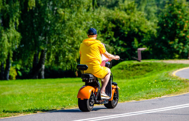 A man rolls on an electric scooter in the Park
