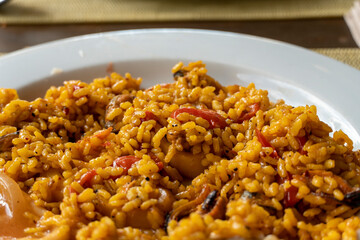 Plate with spanish traditional food - paella - on white background.