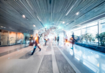A blurry image of a long hallway with people walking in a modern building.