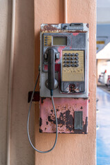 An abandoned nostalgia payphone on the wall evokes a sense of time passing and a world moving away from older technologies.