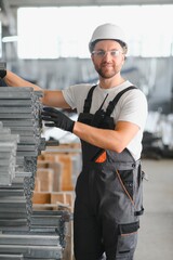 Factory worker measures the metal profile