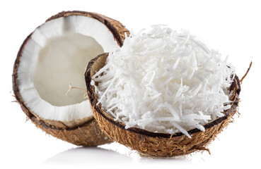 Grated coconut pulp in cracked coconut shell and half of split coconut on white background. File...