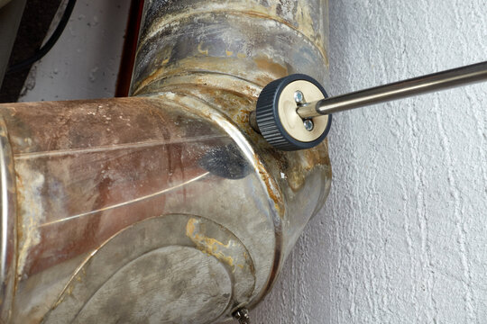 Heating pipe with a probe of a measuring device. Soot and carbon monoxide is tested. Closeup. (BIMSCH and EEG)