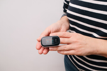 A woman checking her heart rate and oxygenation level. Monitoring Blood Oxygen Levels and Pulse Rate